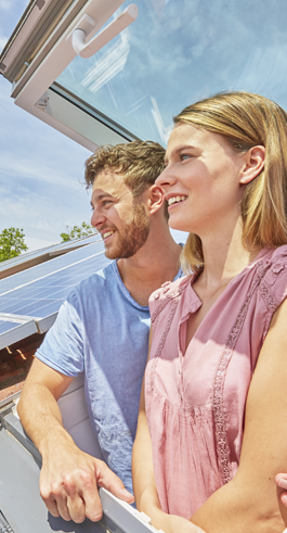 coule looking out of dormer window admiring thier solar panels